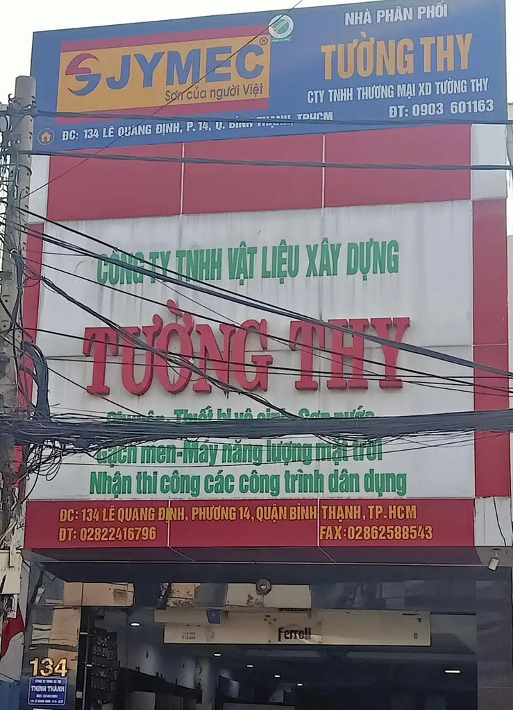 Biển hiệu cửa hàng tiếng Việt với chữ đỏ hiển thị 'TUONG THY' và thông tin kinh doanh khác.