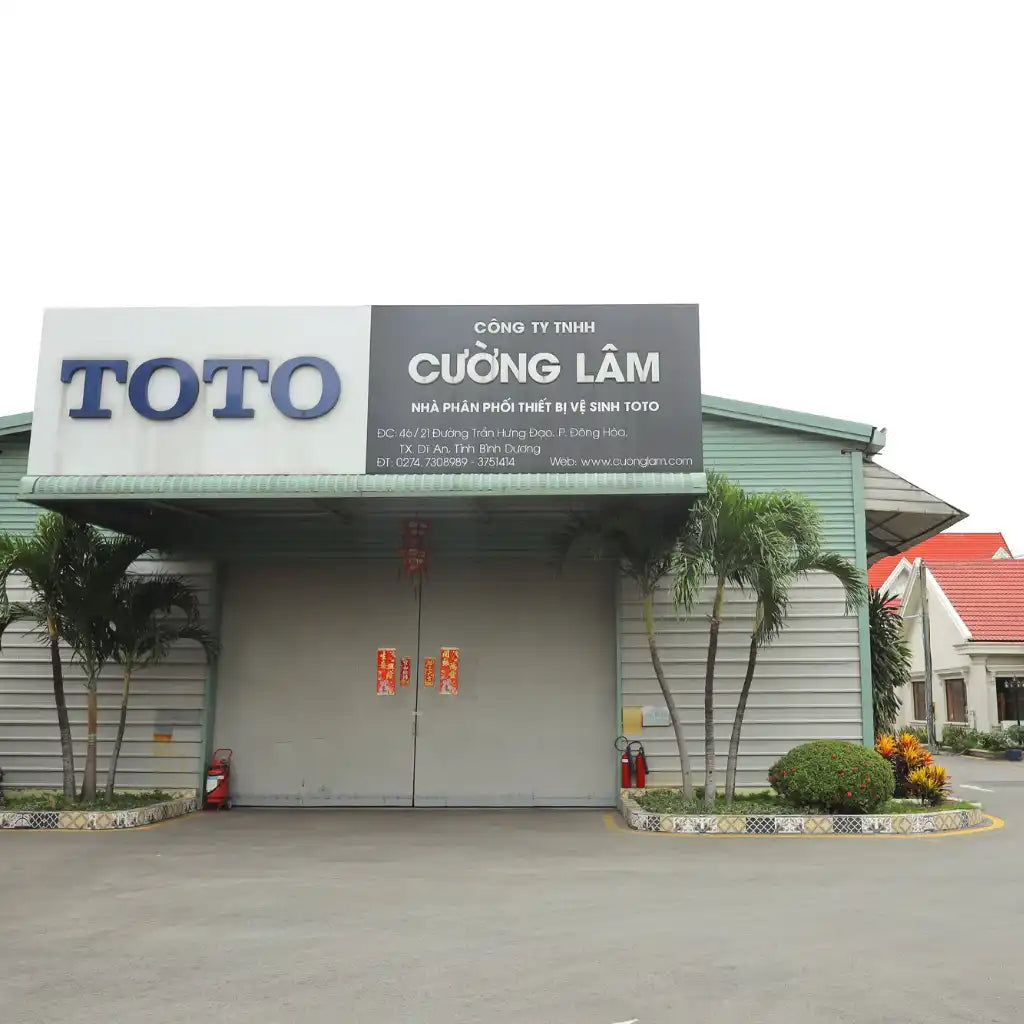 Cửa hàng TOTO có biển hiệu 'CUONG LAM' phía trên cánh cửa kim loại đóng.